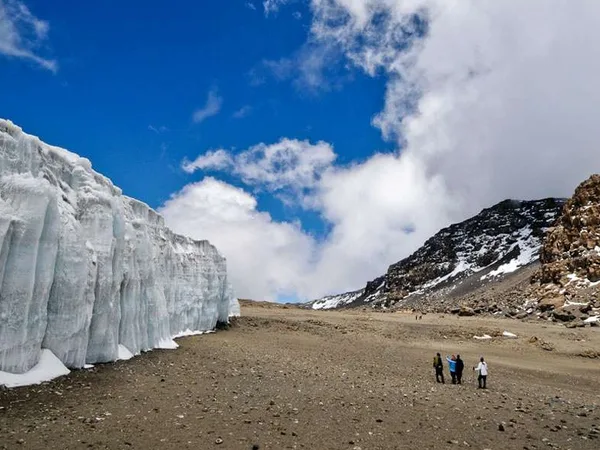 Tourists close to a giant glacier on top of Kilimanjaro after a successful Mount Kilimanjaro hike