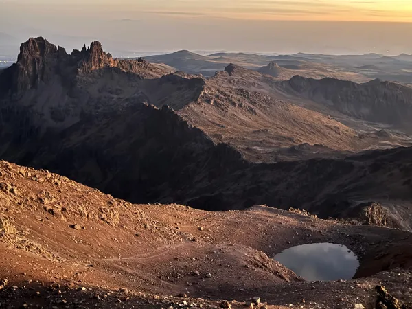 Rugged terrain and lakes of Mt Kenya at high altitude during sunset as seen on a Mount Kenya trek