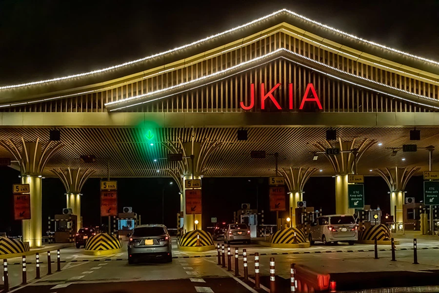 cars passing through Jomo Kenyatta International Airport gate at night on airport transfer service