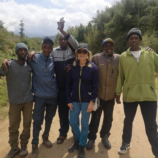 A woman mountain climber posing with male guides and porters. Embarking on a Mount Kenya expedition