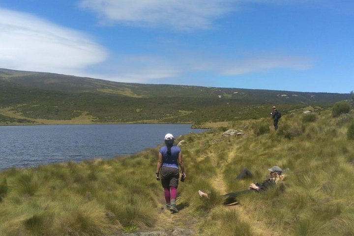 Hikers passing through a lake tarn on Mt Kenya during a Mount Kenya trek on business retreat