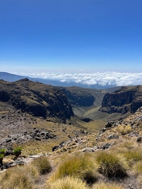 The Gorges Valley Mount Kenya on a clear sunny day with clouds seen ahead and below the landscape