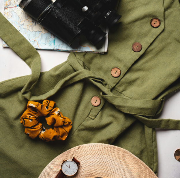 A safari dress, hat, binoculars, map, and watch. Preparations for a Kenya safari trip